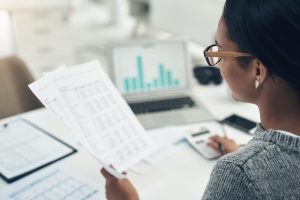 woman glasses audit paperwork office graphs tax return